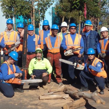 Group picture of men with saws ready to trim trees