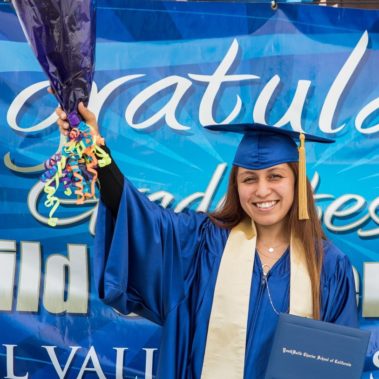 Graduate girl holding flower and her diploma