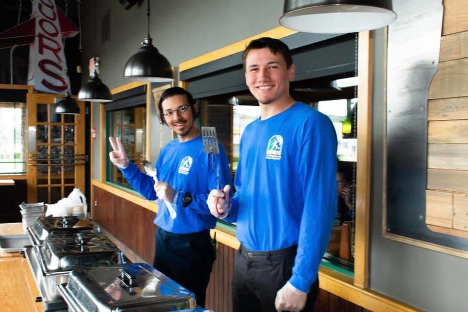 Two teen boy cooking together with smiles